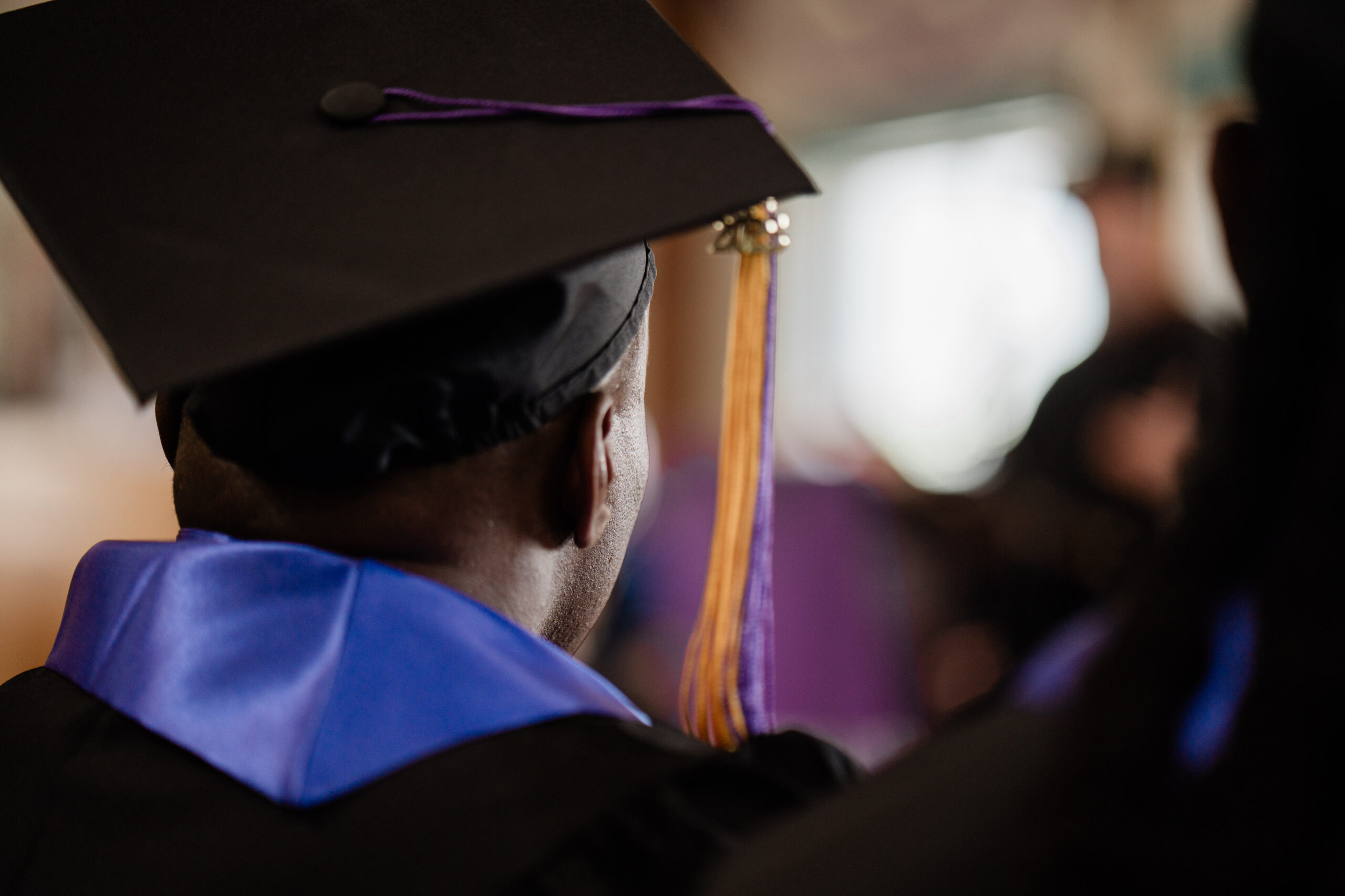 A graduate of the College in Prison program during their commencement ceremony, dressed in regalia