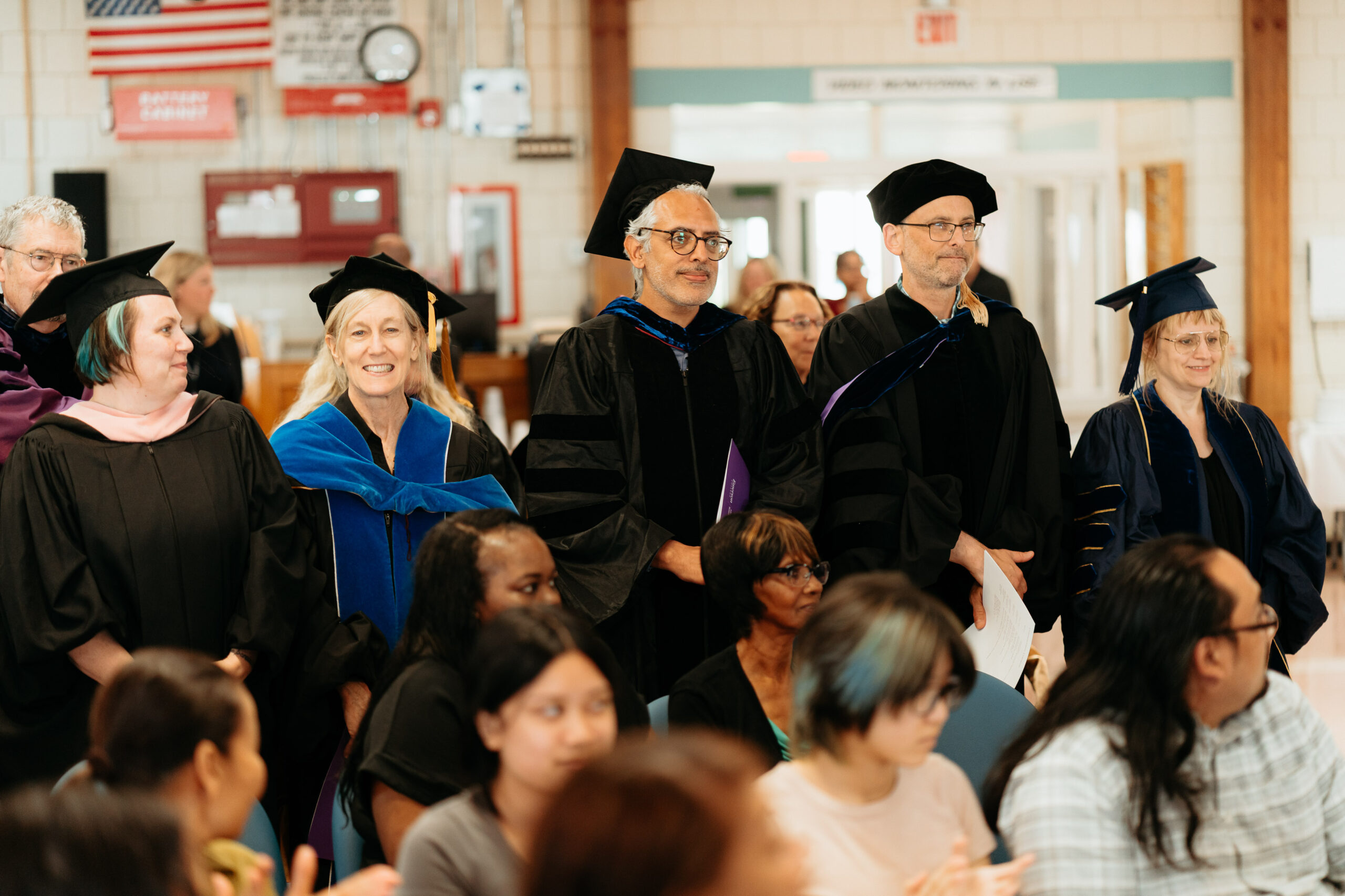 Faculty members in the EPI program standing in recognition during the EPI commencement ceremony